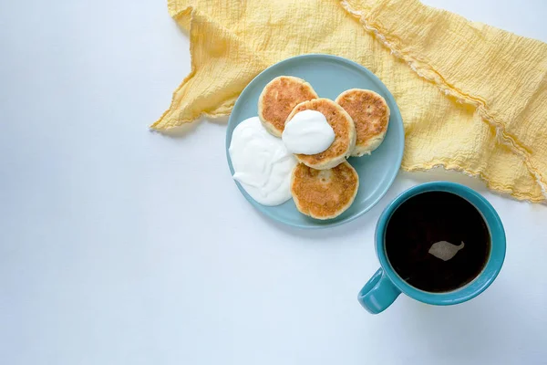 Läckra ostpannkakor, Syrniki, serveras med gräddfil. Utsikt ovanifrån. Royaltyfria Stockbilder