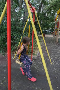 Evin bahçesinde salıncakta sallanan şık bir çocuk..
