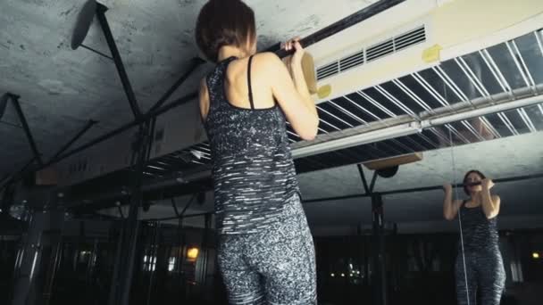 Atleta femenina haciendo pull-ups estándar en el gimnasio cámara lenta — Vídeo de stock