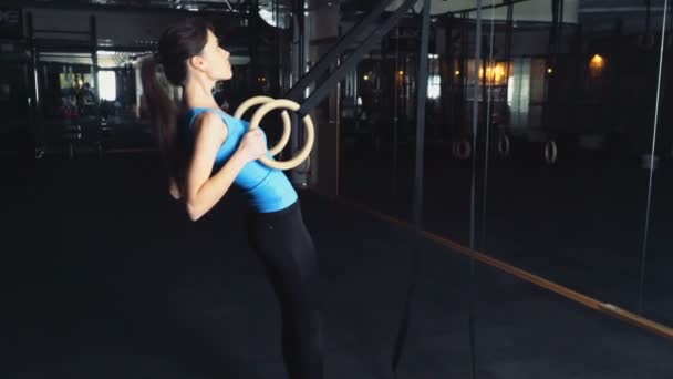 Joven hembra haciendo ring row en el gimnasio cámara lenta — Vídeo de stock