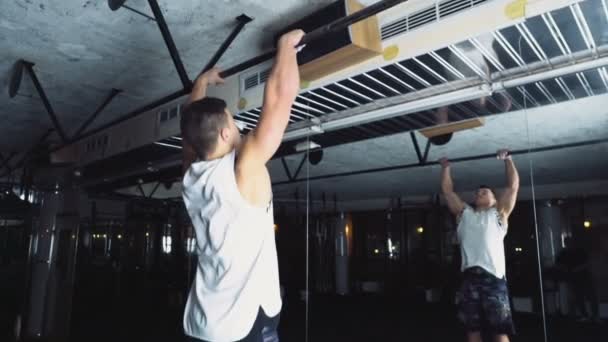 Atleta masculino haciendo pull-ups estándar en el gimnasio cámara lenta — Vídeos de Stock