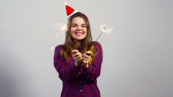 Молодая девушка в рождественской шляпе и двух искрах счастливых эмоций — стоковое видео