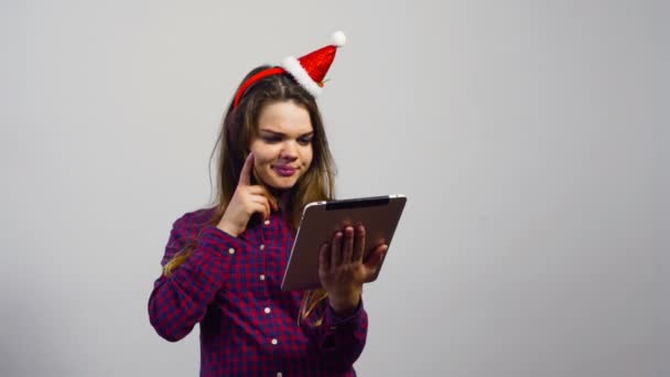 Muchacha joven con sombrero de Navidad hacer compras en línea con la computadora de la tableta — Vídeos de Stock