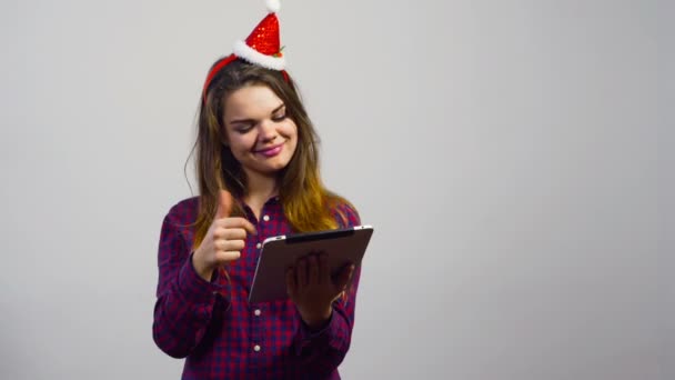 Muchacha joven con sombrero de Navidad hacer compras en línea con la computadora de la tableta — Vídeos de Stock