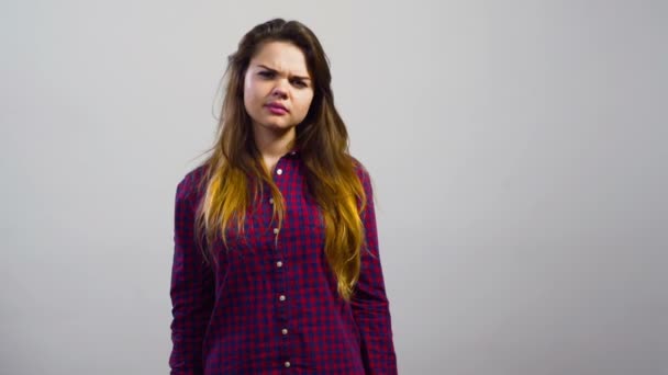 Jovem menina não gosta de emoção na frente da parede branca — Vídeo de Stock