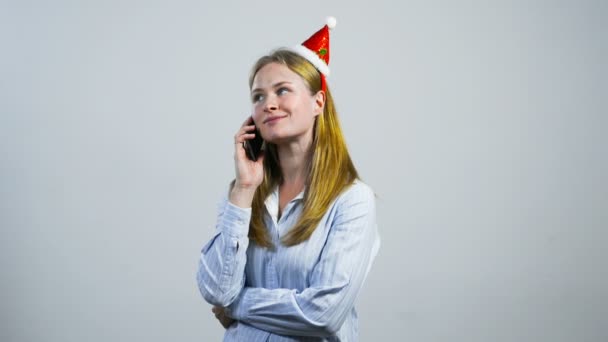 Feliz joven con sombrero de Navidad hablando por teléfono — Vídeos de Stock