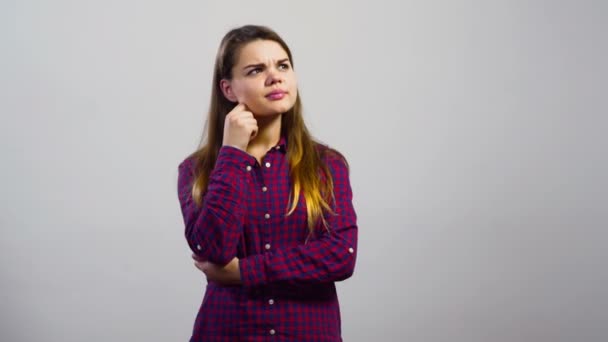 Chica joven tiene una idea delante de la pared blanca — Vídeos de Stock