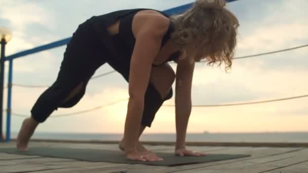 Close up young female practicing yoga on the terrace by the sea — Stock Video