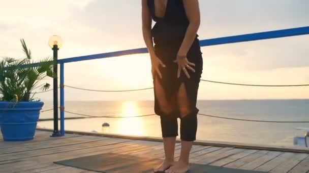 Junge Frau praktiziert Yoga auf der Terrasse am Meer — Stockvideo