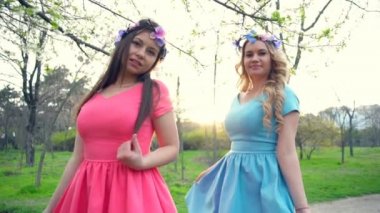 iki kız altınla çiçek bahar çiçeği içinde poz giyen yavaş hareket park