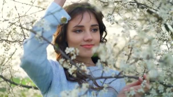 Hermosa joven hembra en medio de la flor del árbol de primavera cámara lenta — Vídeos de Stock