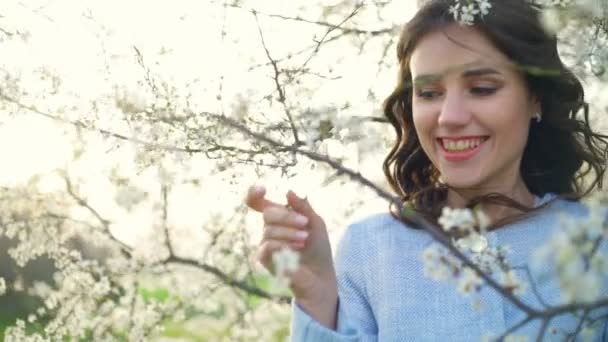 Vacker ung kvinna mitt i våren träd blossom slow motion — Stockvideo