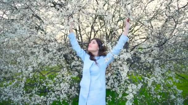 Vacker ung kvinna mitt i våren träd blossom slow motion — Stockvideo