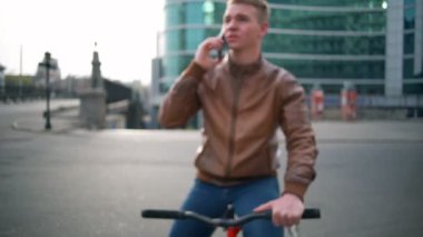 genç erkek bisikletçi görüşmeler şehir ağır çekimde telefonda