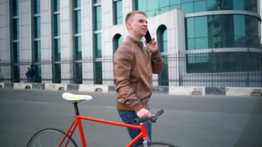 Bisiklet sokak ağır çekimde yakınındaki telefon erkek bisikletçi konuşmak yürür