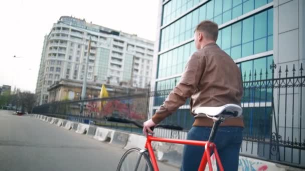 Ciclista masculino caminha perto da bicicleta na rua câmera lenta — Vídeo de Stock