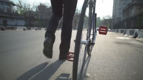 Крупный план мужчина в брюках и классическая обувь идет рядом с велосипедом замедленной съемки — стоковое видео