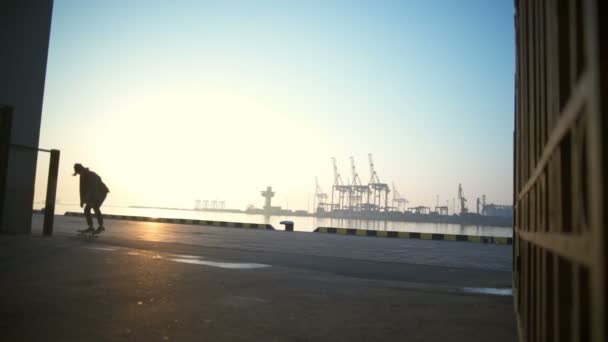 Jovem skate no porto marítimo ao amanhecer câmera lenta — Vídeo de Stock