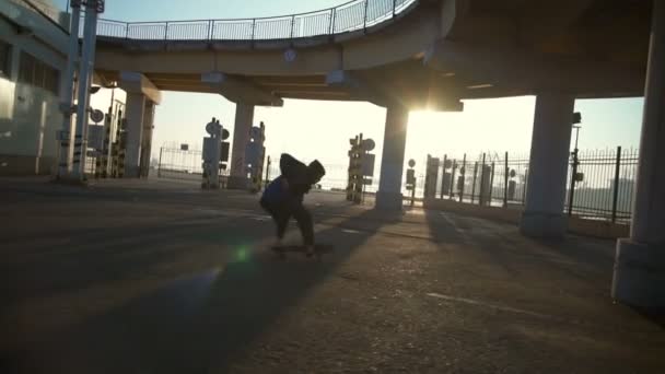 Mladý muž skateboardingu v námořní přístav v svítání zpomalené — Stock video