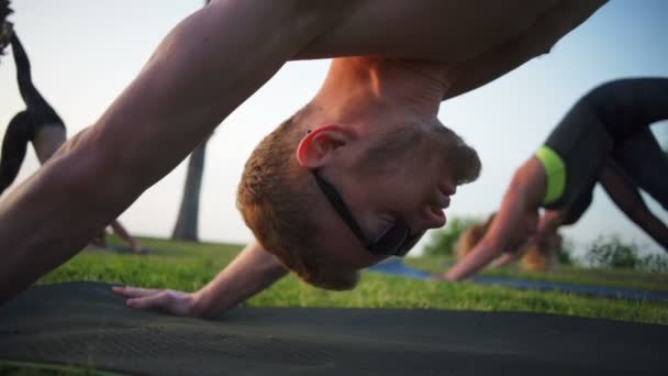 Adam açık havada yoga grup sınıf ağır çekim üzerinde kapatın — Stok video