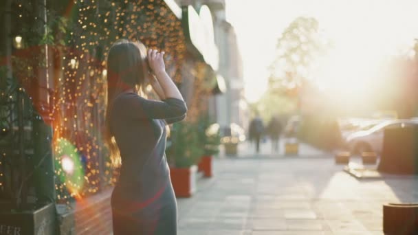 Fiatal nő bevétel mozi-val egy régi fényképezőgép, az utcai lassú mozgás — Stock videók