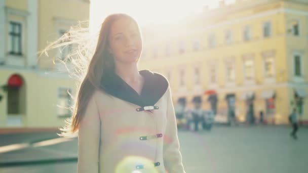 Lachende vrouw in het zonlicht met uitzicht op de stad in slowmotion achtergrond — Stockvideo