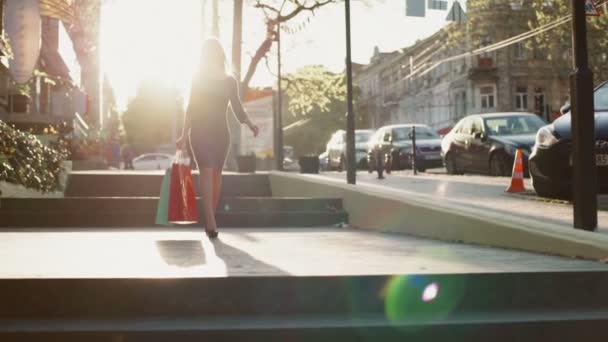 Женщина идет по улице с двумя бумажными пакетами замедленной съемки — стоковое видео