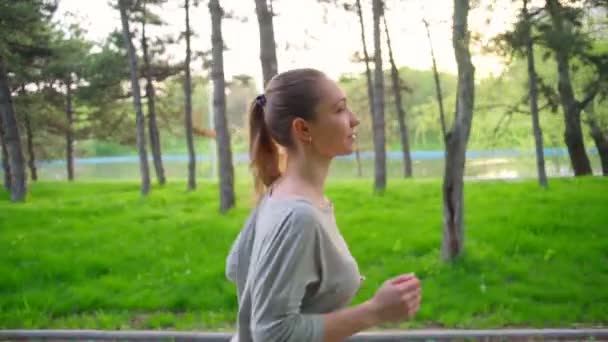 Jovem mulher corre no parque câmera lenta — Vídeo de Stock