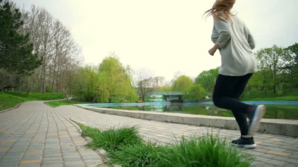 Jonge vrouw uitgevoerd in een slowmotion park — Stockvideo