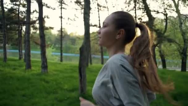 Jovem mulher corre no parque câmera lenta — Vídeo de Stock