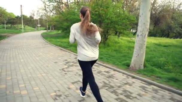 Arrière vue femme courir dans parc ralenti — Video