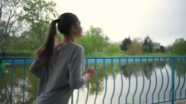 Mujer joven corriendo en un parque de cámara lenta — Vídeos de Stock
