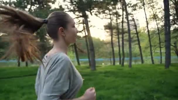 Ung kvinna körs i park slow motion — Stockvideo
