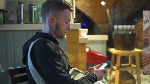 Hombre usando un smartphone en la cafetería cámara lenta — Vídeos de Stock