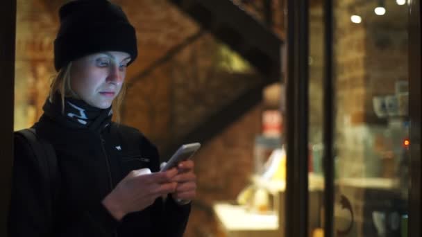 Mujer joven usando un teléfono inteligente en la cafetería cámara lenta — Vídeos de Stock