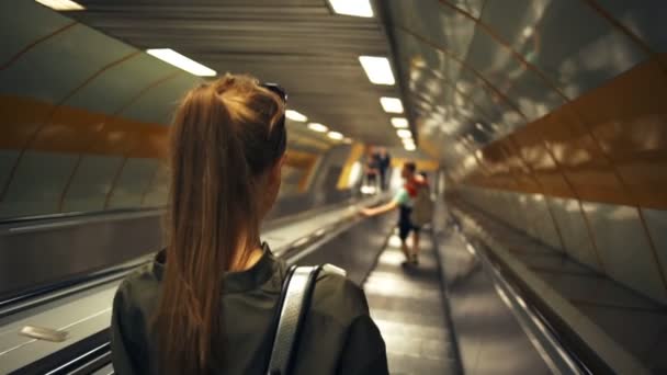 Пара спускается в метро на эскалаторе замедленной съемки — стоковое видео