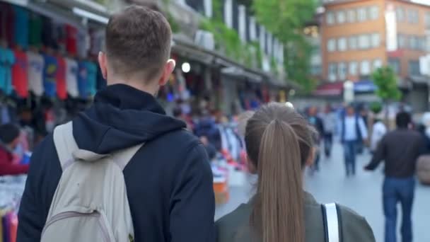 Vista posteriore di una coppia che cammina per strada al rallentatore — Video Stock