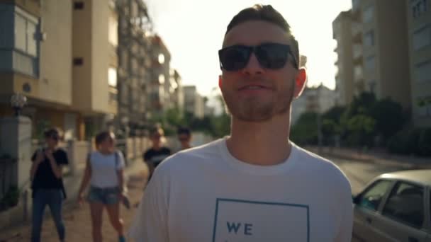 Przystojny mężczyzna w okularach słońca spaceru w ulicy zwolnionym tempie — Wideo stockowe