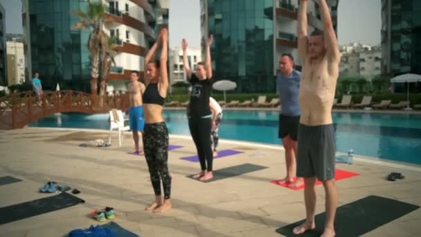 Cours de yoga de groupe près de la piscine au ralenti — Video