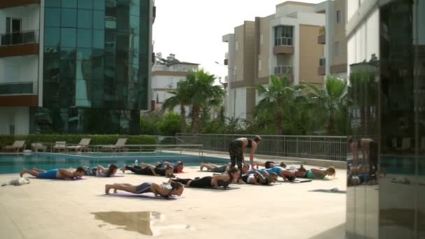 Aula de ioga em grupo perto da piscina câmera lenta — Vídeo de Stock