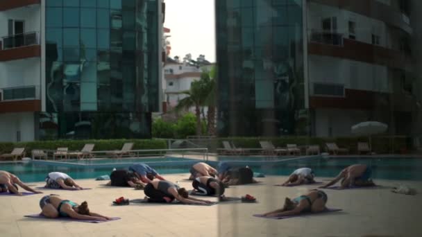 Cours de yoga de groupe près de la piscine au ralenti — Video