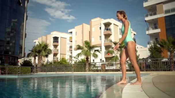 Красивая молодая женщина прыгает в бассейн замедленной съемки — стоковое видео