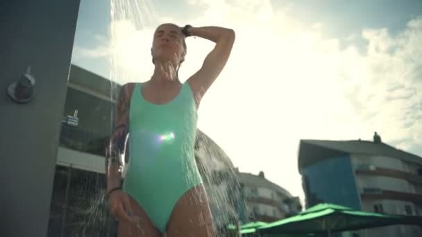 Красивая молодая женщина принимает душ на открытом воздухе замедленной съемки — стоковое видео