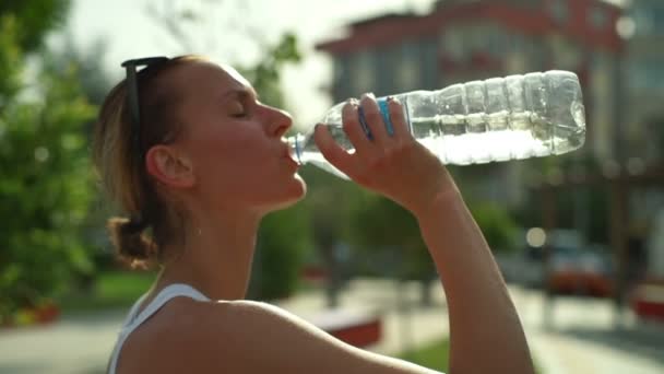 Exhaustas después del ejercicio las mujeres beben agua codiciosamente — Vídeo de stock