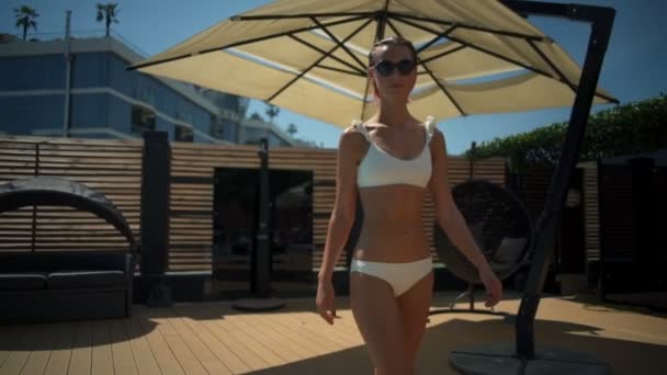 Bella femmina in bikini e occhiali da sole cammina lungo la terrazza slow motion — Video Stock