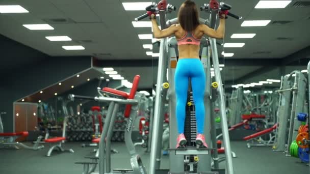 Vista posteriore della donna atletica che fa pull-up in palestra rallentatore — Video Stock