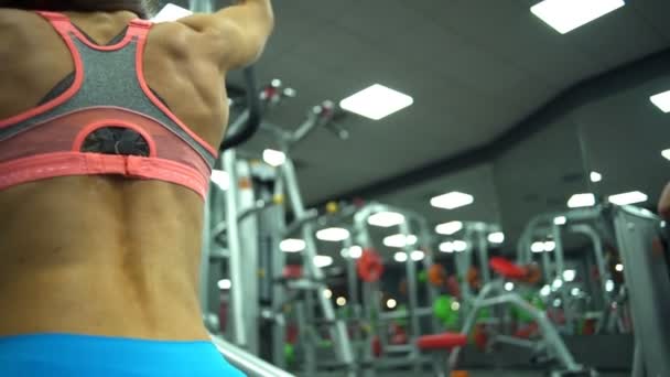 Крупним планом вид спини жіночі вправи на тренері повільний рух — стокове відео