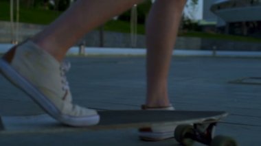 Dolly erkek ayak longboard ve sahil yavaş hareket güneş doğarken üzerinde kapat