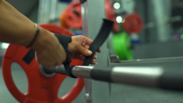 Close-up van de vrouwelijke Fast barbell gordel aan haar arm slow-motion — Stockvideo