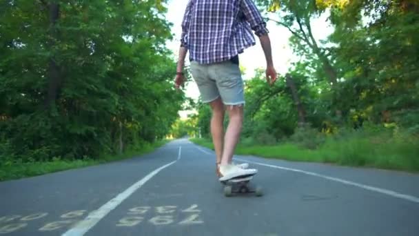 Widok z tyłu mężczyzna jazda longboard w parku zwolnionym tempie — Wideo stockowe
